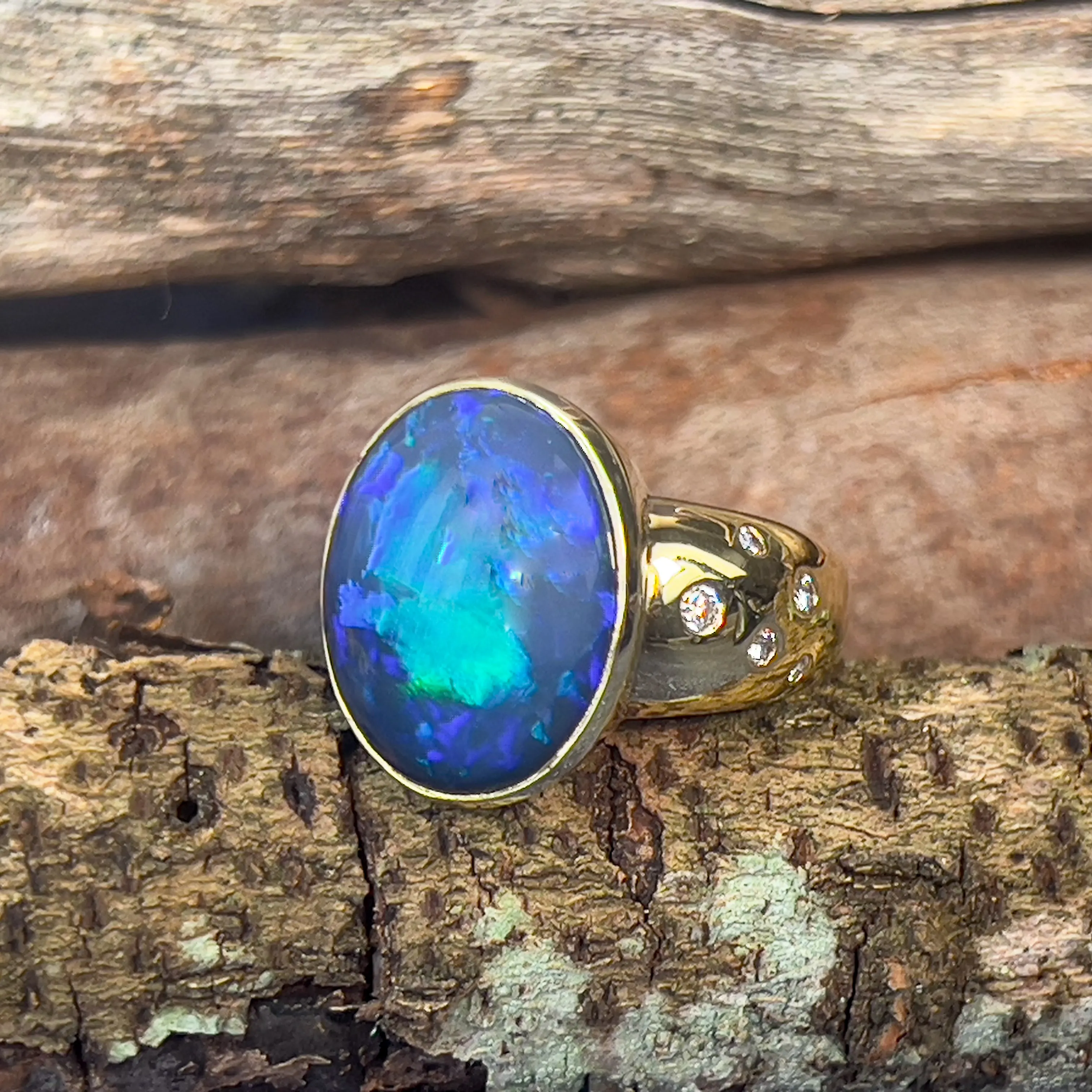 18kt Yellow Gold bezel set band Black Opal 6.05ct and diamonds flush set ring